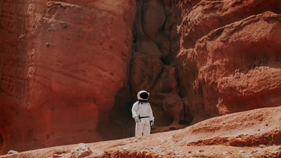 摄影的宇航员站在岩层白天
